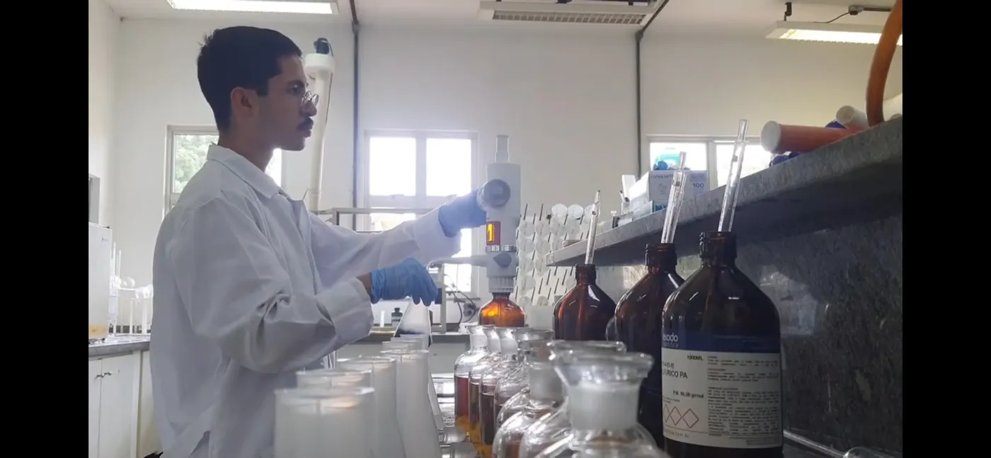 Andrey de jaleco branco analisando amostras no laboratório em Sorocaba